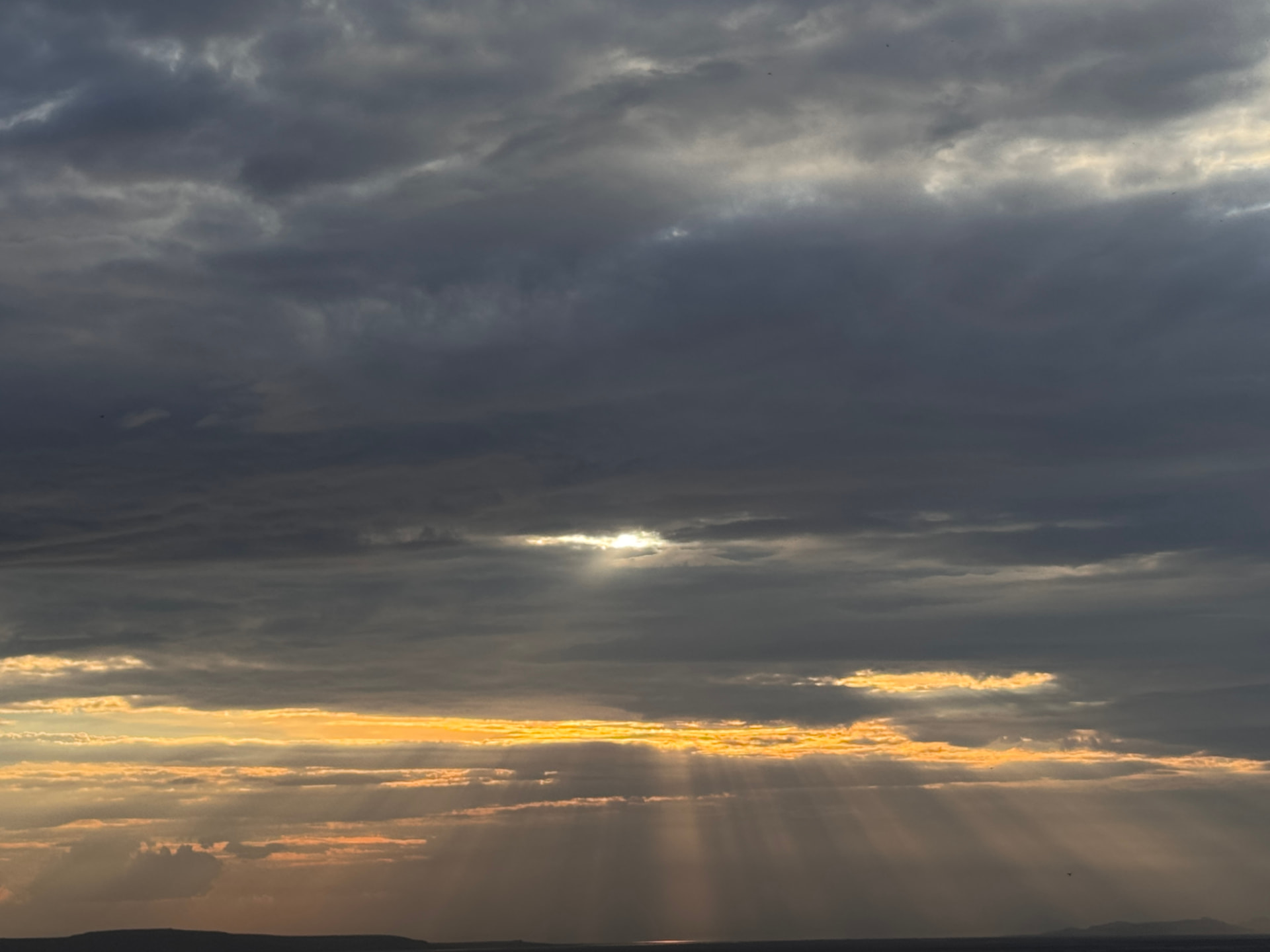 Sun rays breaking through layered clouds.